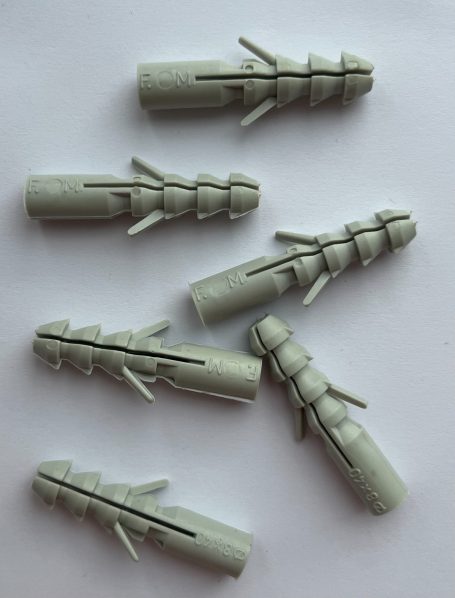 Six grey model parts with fins arranged randomly on a light background.